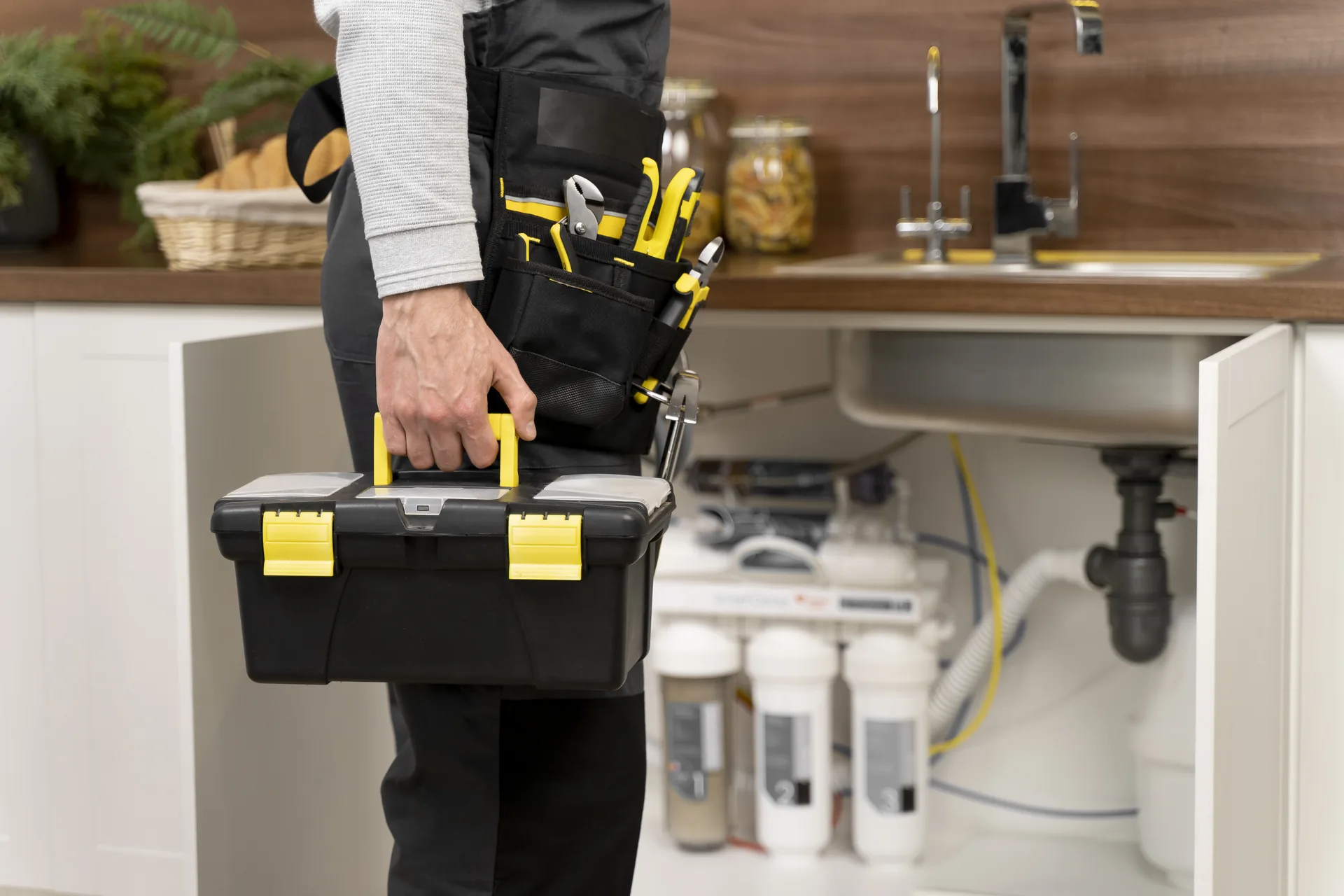 Serwisant przy instalacji hydraulicznej w kuchni lokalu